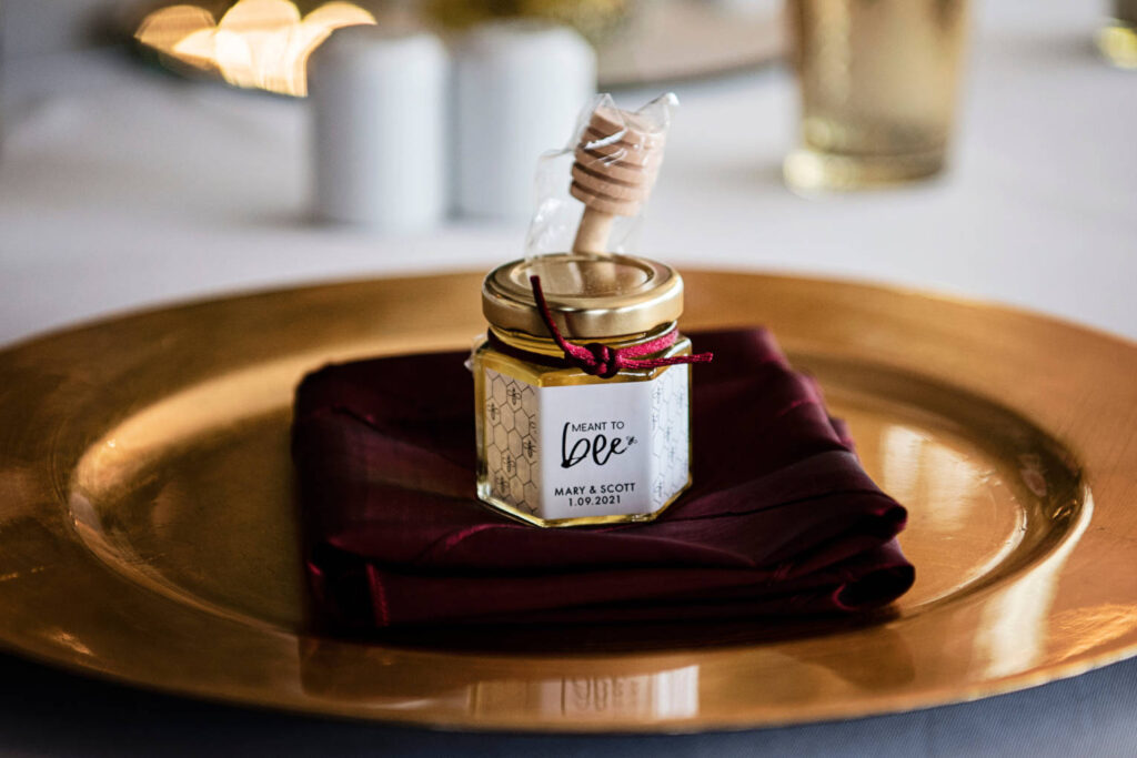 A pot of honey with mini stick – wedding favours