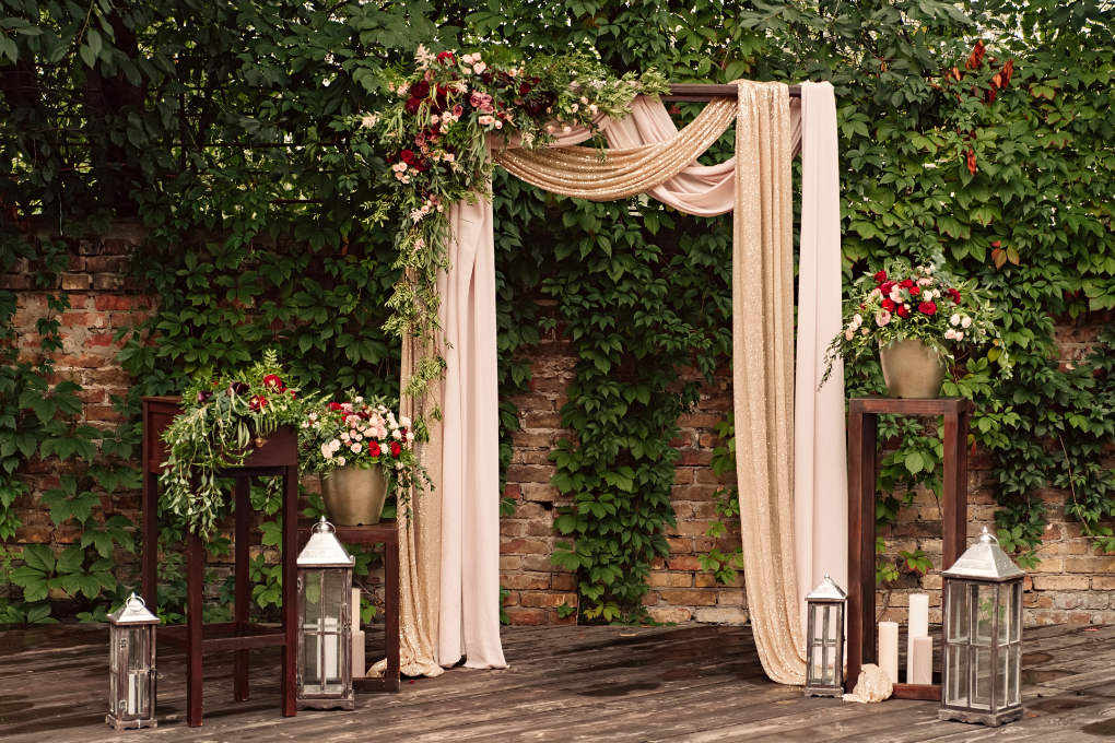 Wedding ceremony arch ideas - pink draped fabric and flowers on a wooden structure